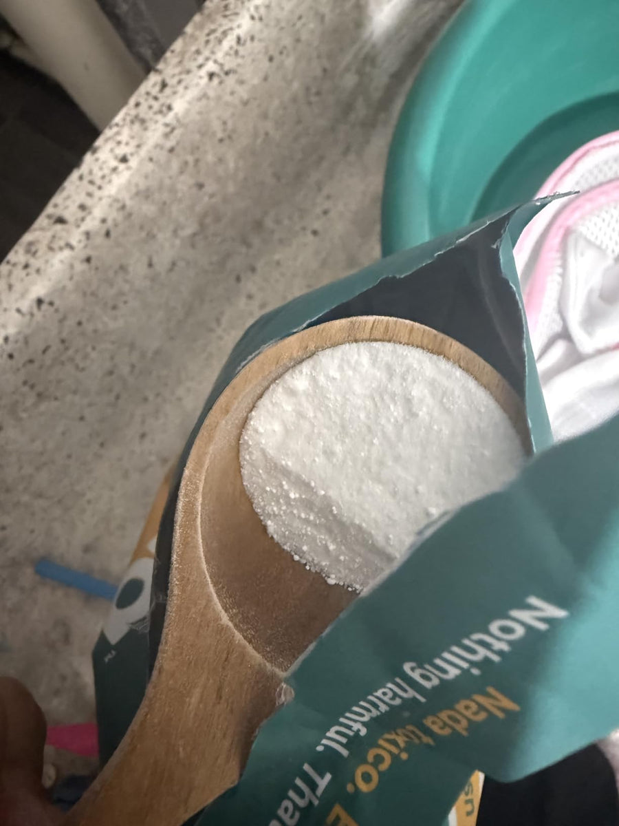 El detergente y la cuchara de madera de cerca.